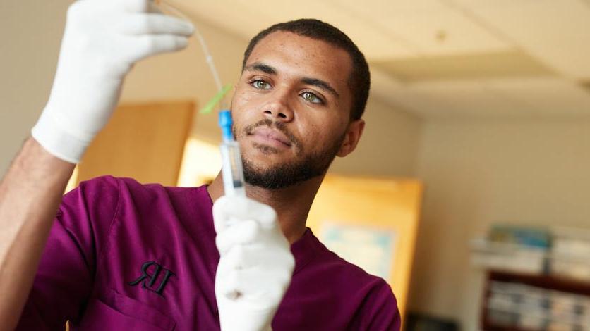 Nursing students works with line in nursing lab